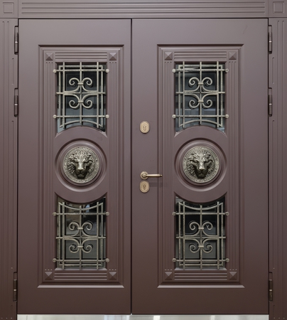 Равностворчатая входная термодверь с ковкой, стеклами и чеканкой «голова льва» (отделка МДФ коричневого цвета)